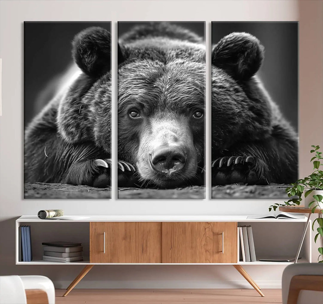 The black and white triptych, titled "Resting Grizzly 399 Bear Canvas Print," is a perfect gift for nature enthusiasts. Displaying a grizzly bear lying down, this wildlife art piece incorporates nautical elements like ships and a diving helmet, adding intriguing details to its rustic cabin and farmhouse decor vibe.