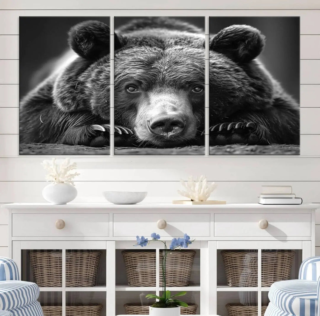 The black and white triptych, titled "Resting Grizzly 399 Bear Canvas Print," is a perfect gift for nature enthusiasts. Displaying a grizzly bear lying down, this wildlife art piece incorporates nautical elements like ships and a diving helmet, adding intriguing details to its rustic cabin and farmhouse decor vibe.