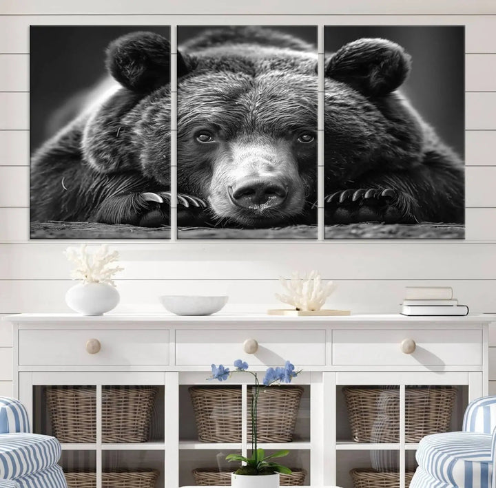 The black and white triptych, titled "Resting Grizzly 399 Bear Canvas Print," is a perfect gift for nature enthusiasts. Displaying a grizzly bear lying down, this wildlife art piece incorporates nautical elements like ships and a diving helmet, adding intriguing details to its rustic cabin and farmhouse decor vibe.