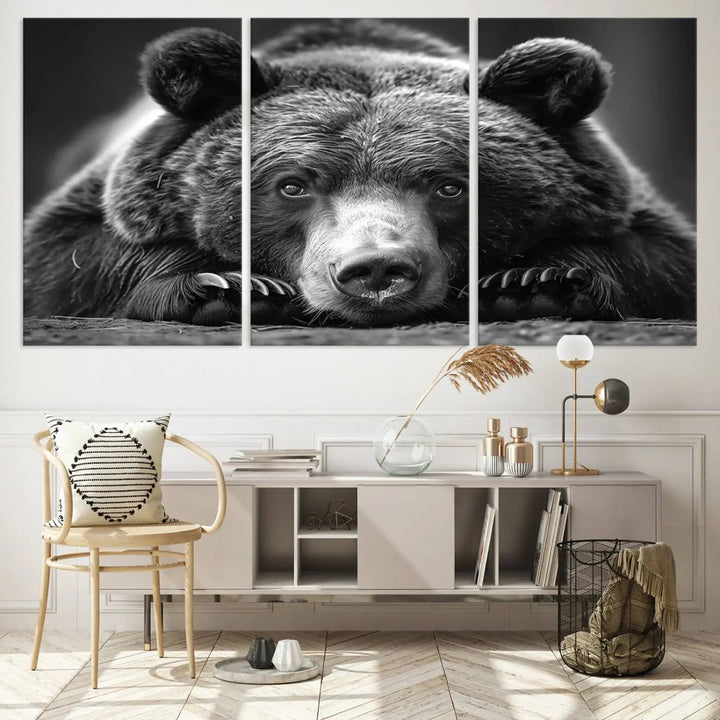 The black and white triptych, titled "Resting Grizzly 399 Bear Canvas Print," is a perfect gift for nature enthusiasts. Displaying a grizzly bear lying down, this wildlife art piece incorporates nautical elements like ships and a diving helmet, adding intriguing details to its rustic cabin and farmhouse decor vibe.