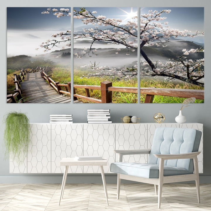 Canvas wall art featuring a scenic wooden walkway surrounded by cherry blossoms and misty mountains, ready to hang.