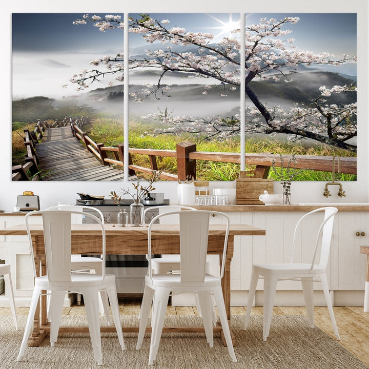 Canvas wall art featuring a scenic wooden walkway surrounded by cherry blossoms and misty mountains, ready to hang.