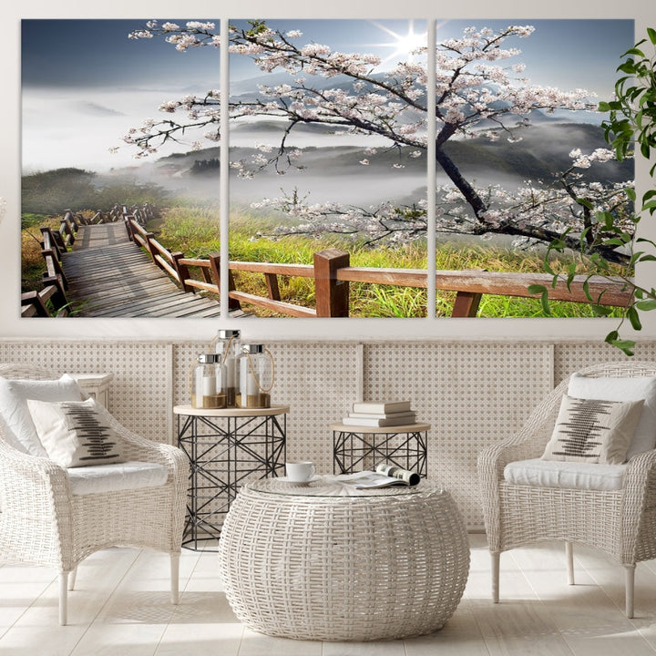 Canvas wall art featuring a scenic wooden walkway surrounded by cherry blossoms and misty mountains, ready to hang.