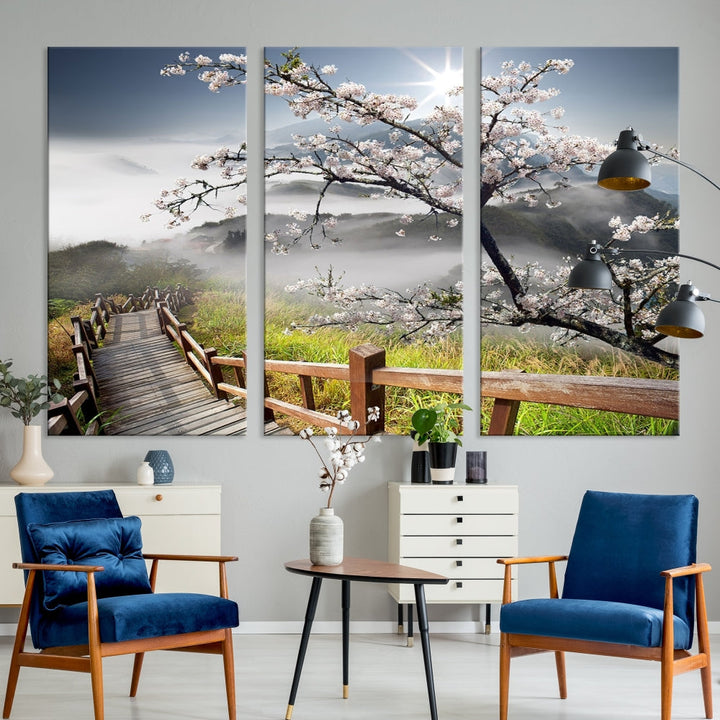 Canvas wall art featuring a scenic wooden walkway surrounded by cherry blossoms and misty mountains, ready to hang.