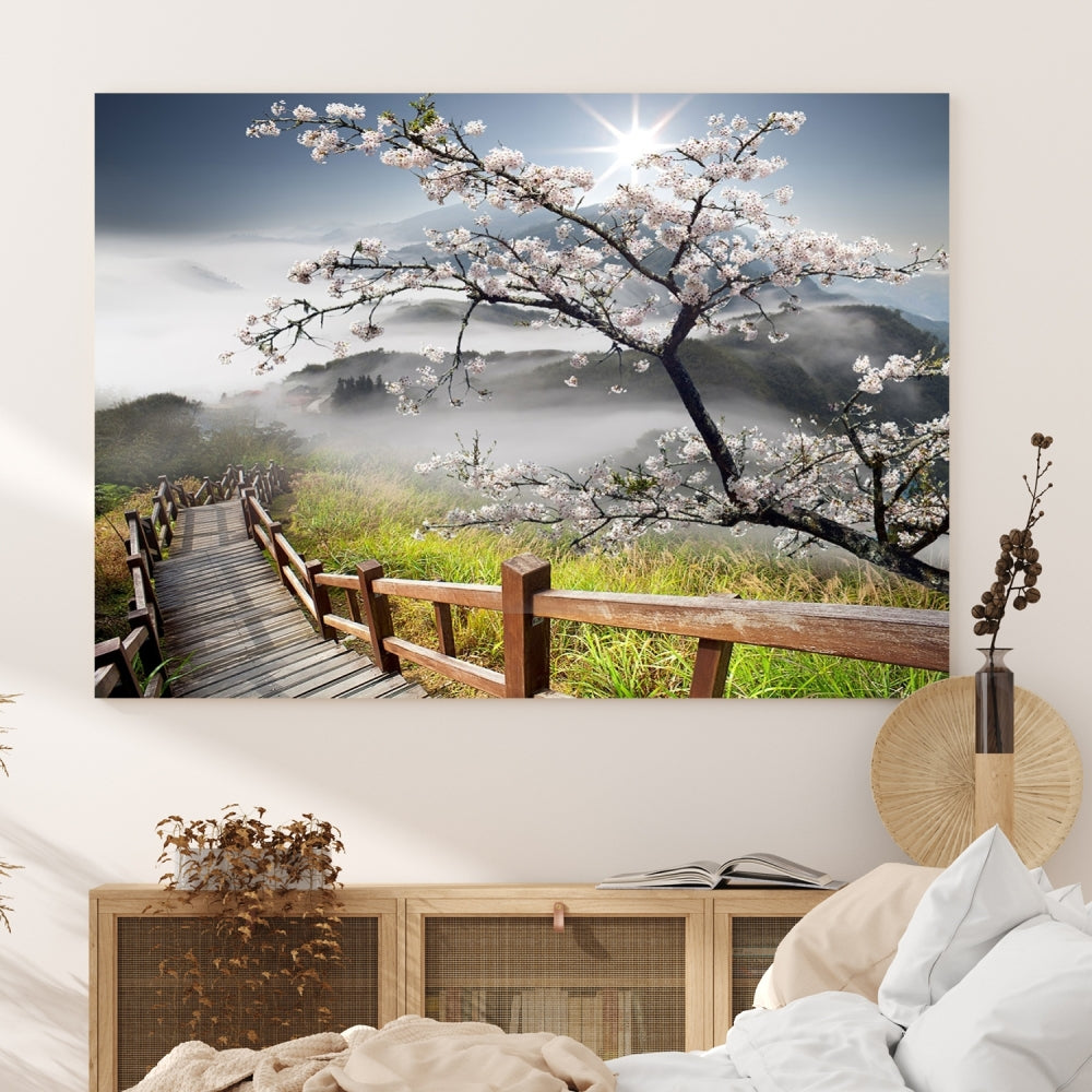 Canvas wall art featuring a scenic wooden walkway surrounded by cherry blossoms and misty mountains, ready to hang.