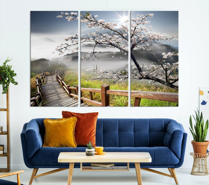 Canvas wall art featuring a scenic wooden walkway surrounded by cherry blossoms and misty mountains, ready to hang.