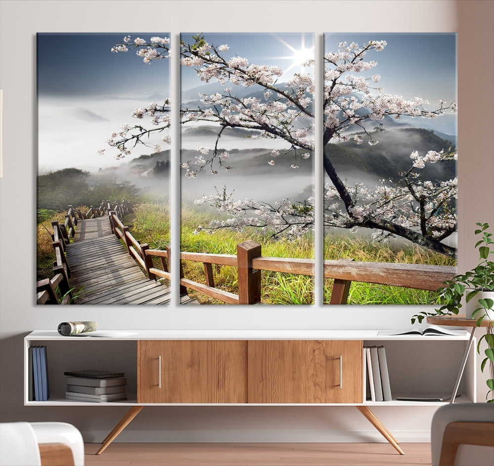 Canvas wall art featuring a scenic wooden walkway surrounded by cherry blossoms and misty mountains, ready to hang.