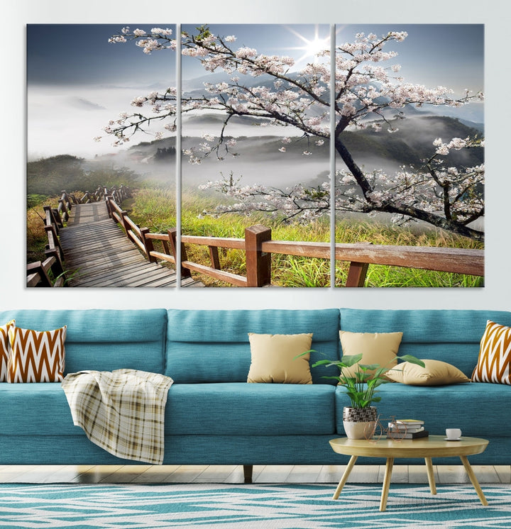 Canvas wall art featuring a scenic wooden walkway surrounded by cherry blossoms and misty mountains, ready to hang.