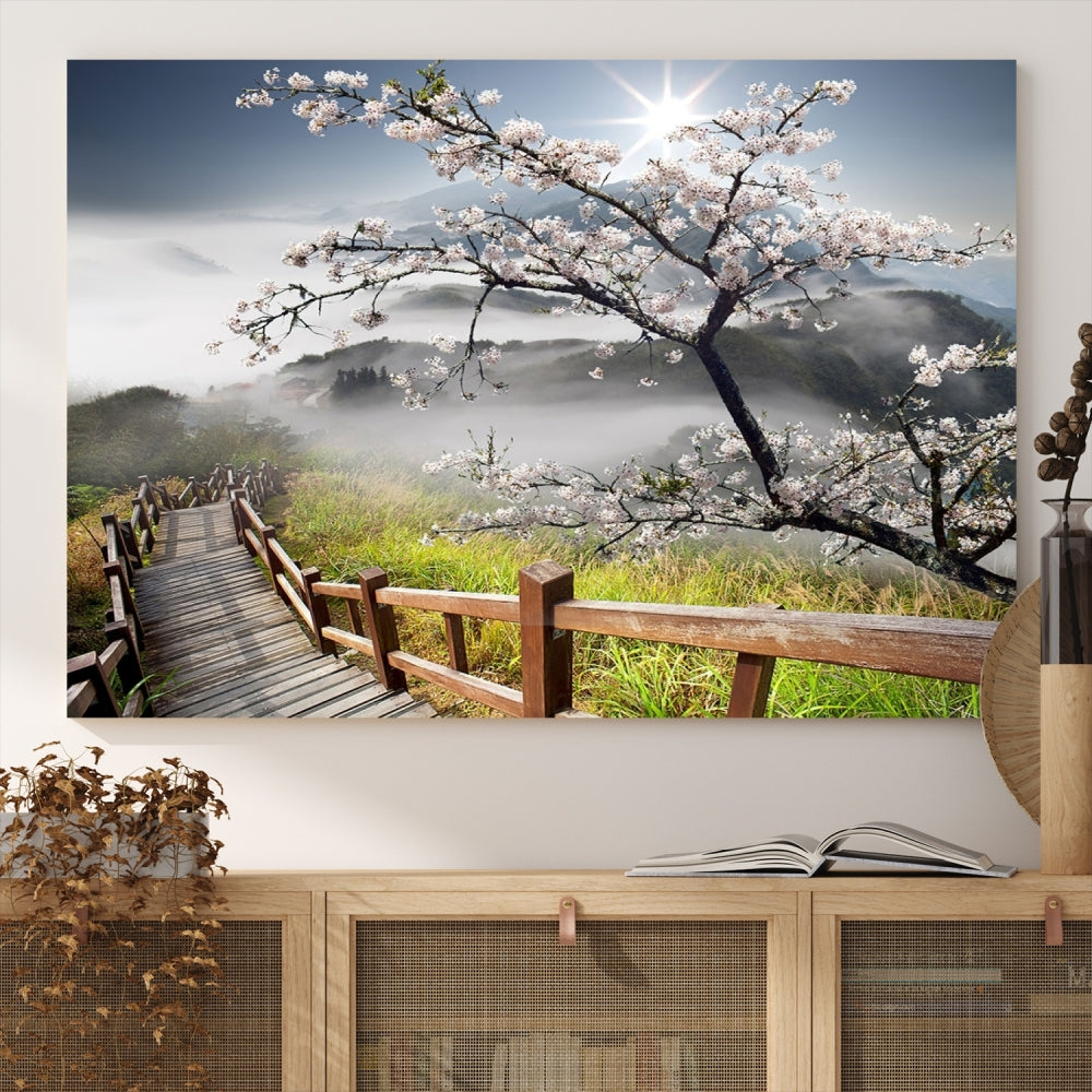 Canvas wall art featuring a scenic wooden walkway surrounded by cherry blossoms and misty mountains, ready to hang.