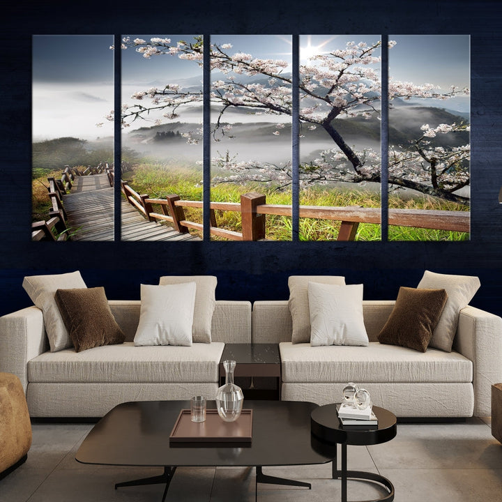 Canvas wall art featuring a scenic wooden walkway surrounded by cherry blossoms and misty mountains, ready to hang.