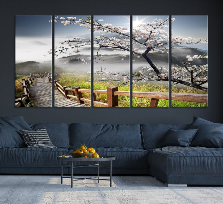 Canvas wall art featuring a scenic wooden walkway surrounded by cherry blossoms and misty mountains, ready to hang.