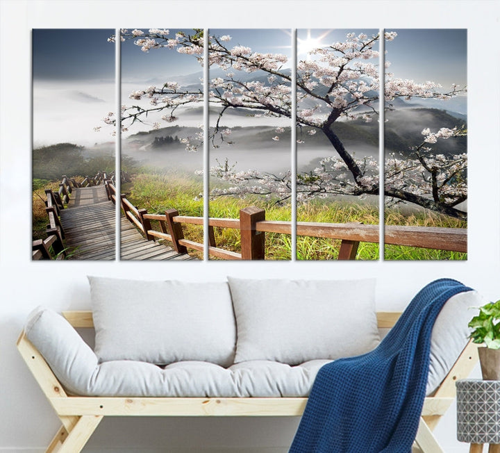 Canvas wall art featuring a scenic wooden walkway surrounded by cherry blossoms and misty mountains, ready to hang.