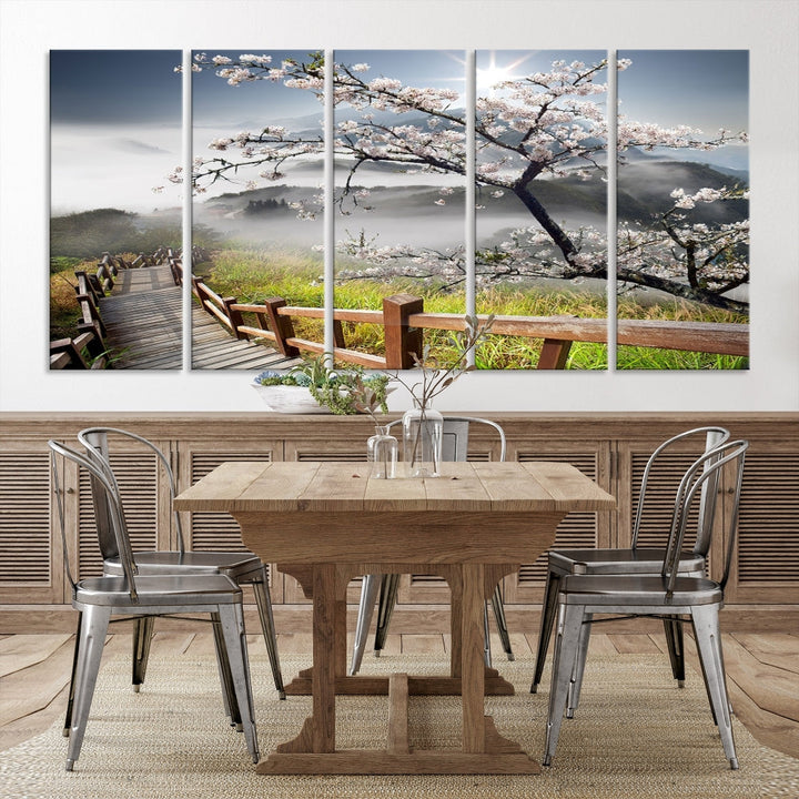 Canvas wall art featuring a scenic wooden walkway surrounded by cherry blossoms and misty mountains, ready to hang.