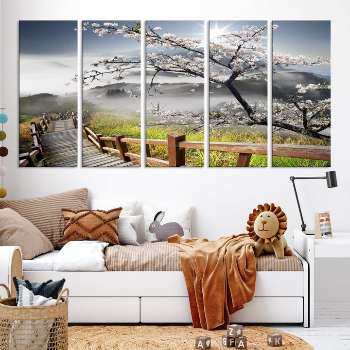 Canvas wall art featuring a scenic wooden walkway surrounded by cherry blossoms and misty mountains, ready to hang.