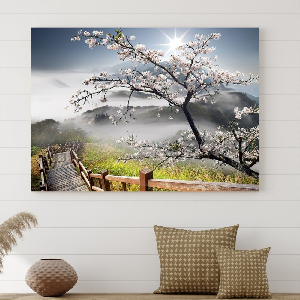 Canvas wall art featuring a scenic wooden walkway surrounded by cherry blossoms and misty mountains, ready to hang.