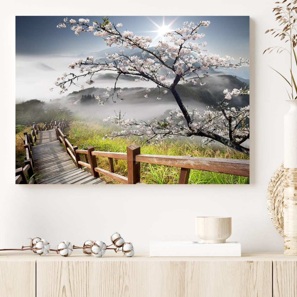 Canvas wall art featuring a scenic wooden walkway surrounded by cherry blossoms and misty mountains, ready to hang.