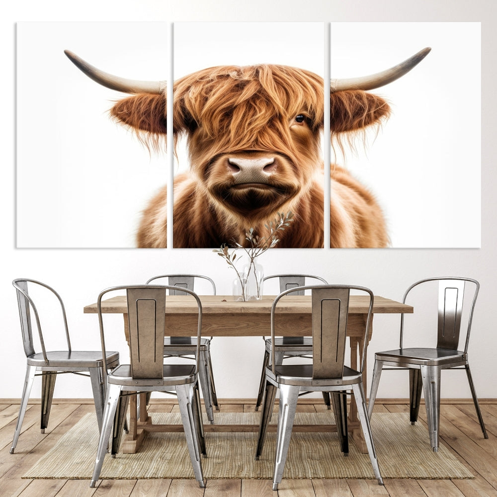 A Scottish Highland Cow Canvas Print, featuring a trio of panels depicting a long-haired, large-horned Highland cow on museum-quality canvas with UV protection, was displayed.