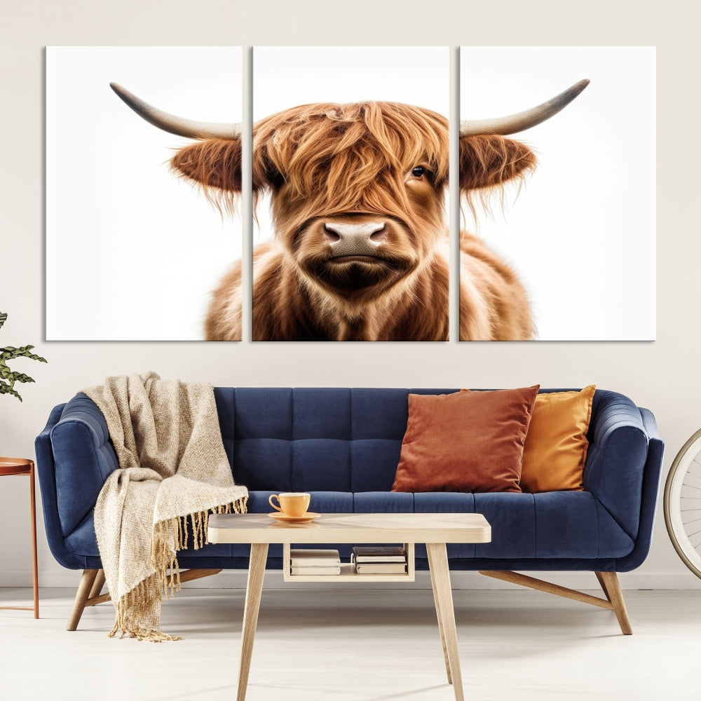 A Scottish Highland Cow Canvas Print, featuring a trio of panels depicting a long-haired, large-horned Highland cow on museum-quality canvas with UV protection, was displayed.