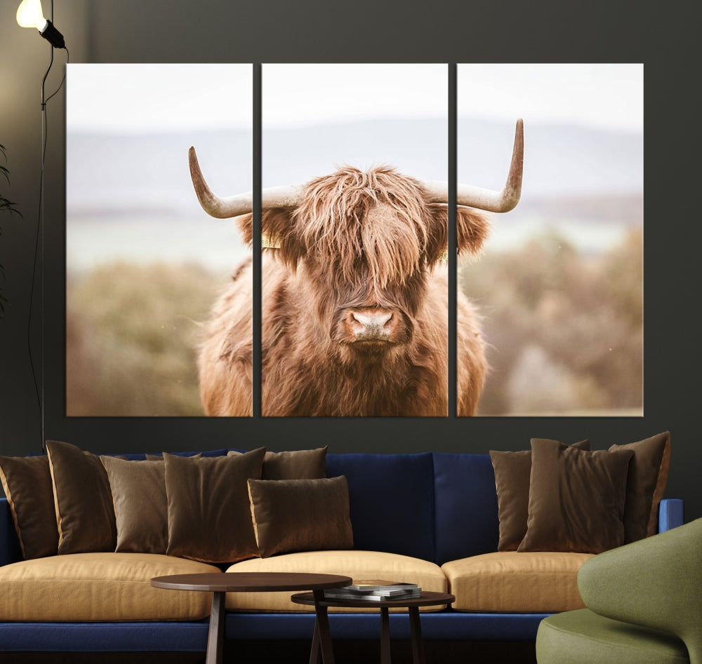 The Scottish Highland Cow Canvas Wall Art features a serene depiction of a Highland cow in natural pastel tones, adding an elegant touch to the farmhouse-inspired decor.