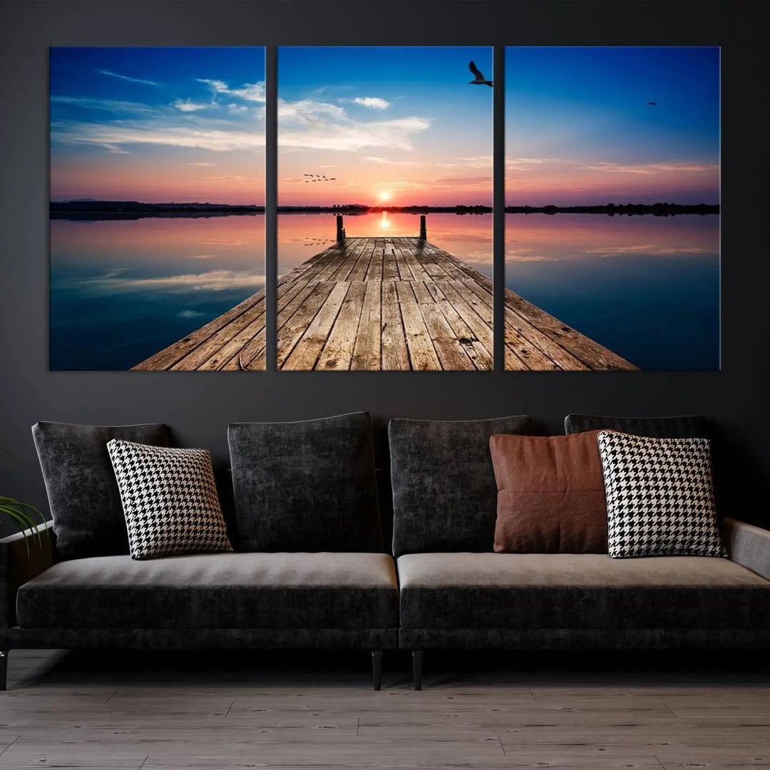 A Sea Wooden Pier Canvas Wall Art, featuring a sunset artwork print of the beach, fosters a coastal ambiance in the modern living room.