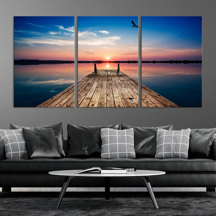 A Sea Wooden Pier Canvas Wall Art, featuring a sunset artwork print of the beach, fosters a coastal ambiance in the modern living room.