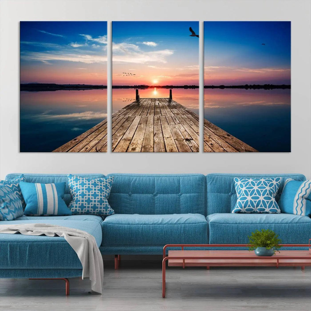 A Sea Wooden Pier Canvas Wall Art, featuring a sunset artwork print of the beach, fosters a coastal ambiance in the modern living room.