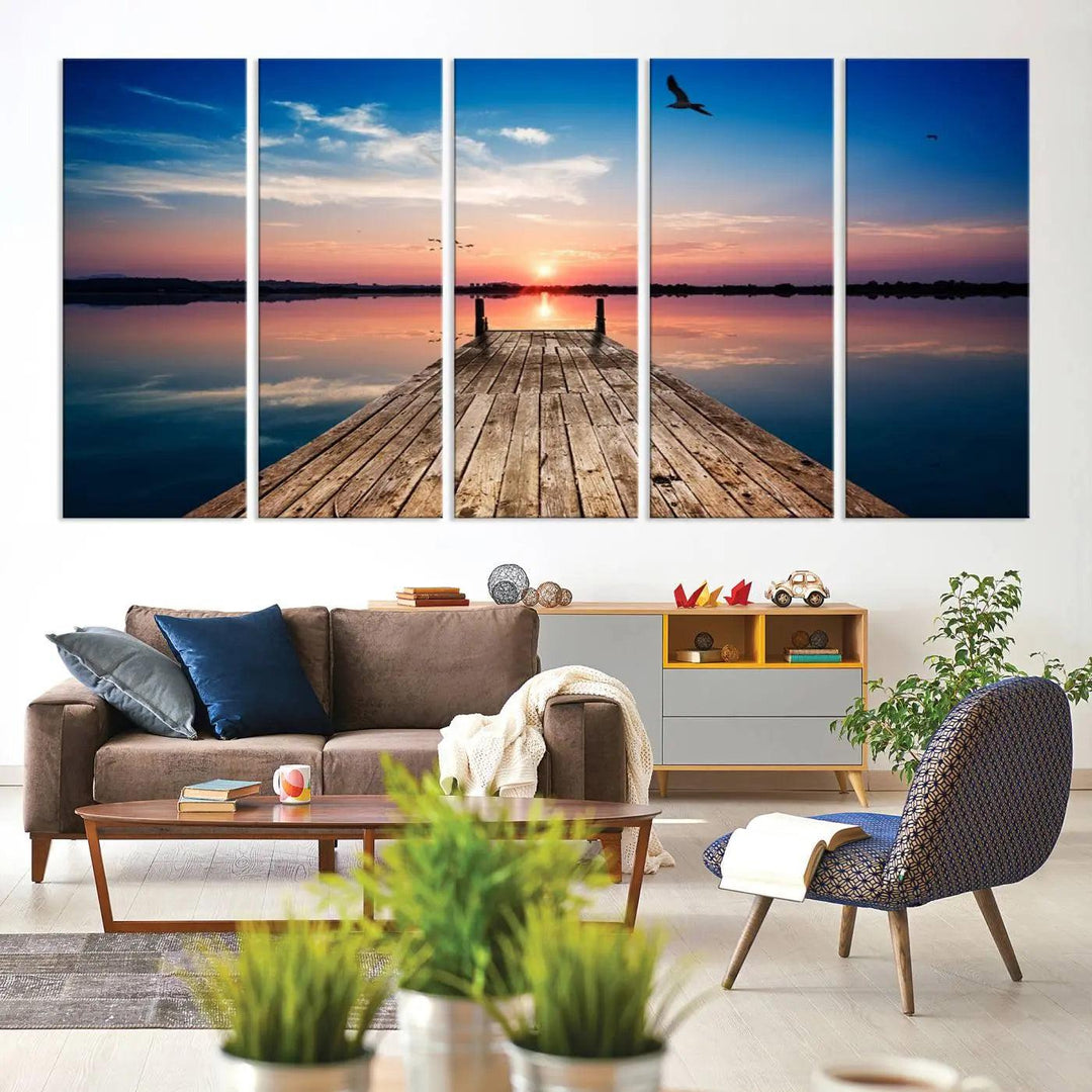 A Sea Wooden Pier Canvas Wall Art, featuring a sunset artwork print of the beach, fosters a coastal ambiance in the modern living room.