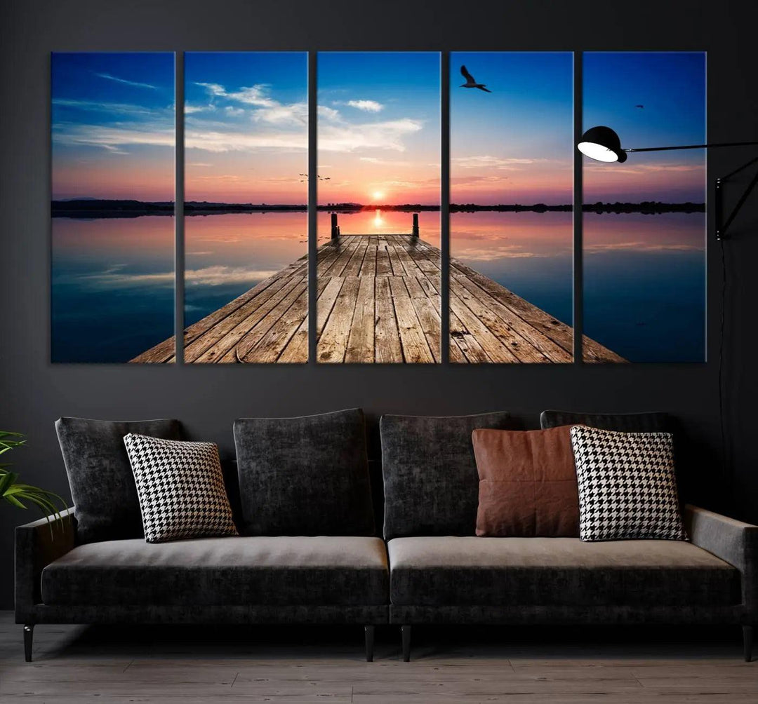 A Sea Wooden Pier Canvas Wall Art, featuring a sunset artwork print of the beach, fosters a coastal ambiance in the modern living room.