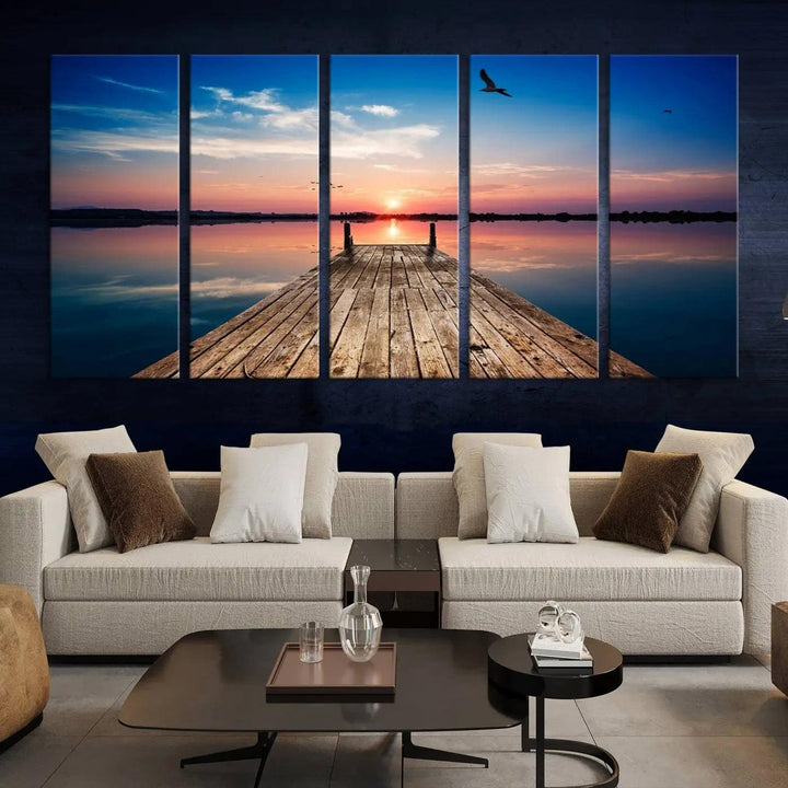 A Sea Wooden Pier Canvas Wall Art, featuring a sunset artwork print of the beach, fosters a coastal ambiance in the modern living room.