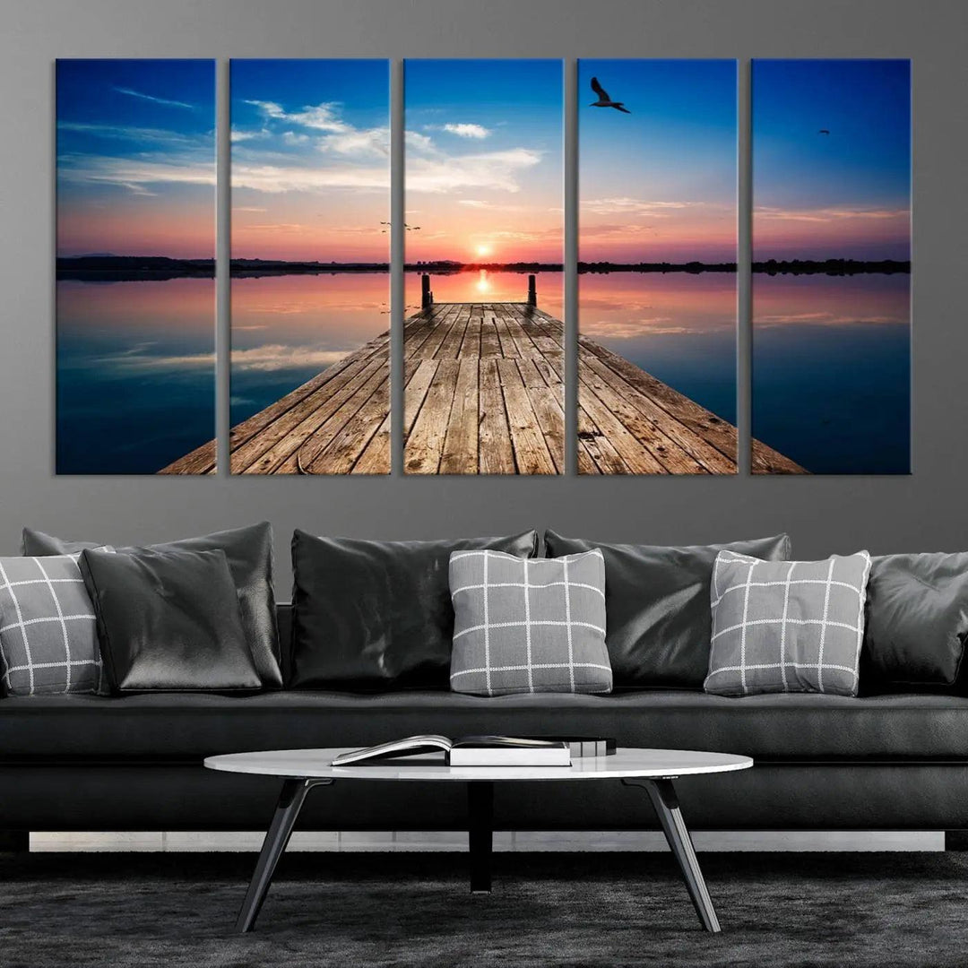 A Sea Wooden Pier Canvas Wall Art, featuring a sunset artwork print of the beach, fosters a coastal ambiance in the modern living room.