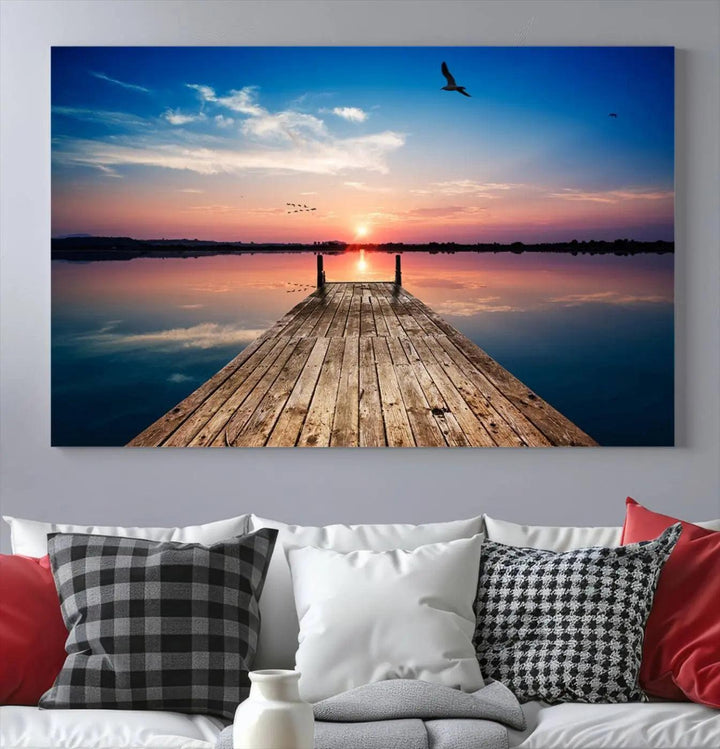 A Sea Wooden Pier Canvas Wall Art, featuring a sunset artwork print of the beach, fosters a coastal ambiance in the modern living room.