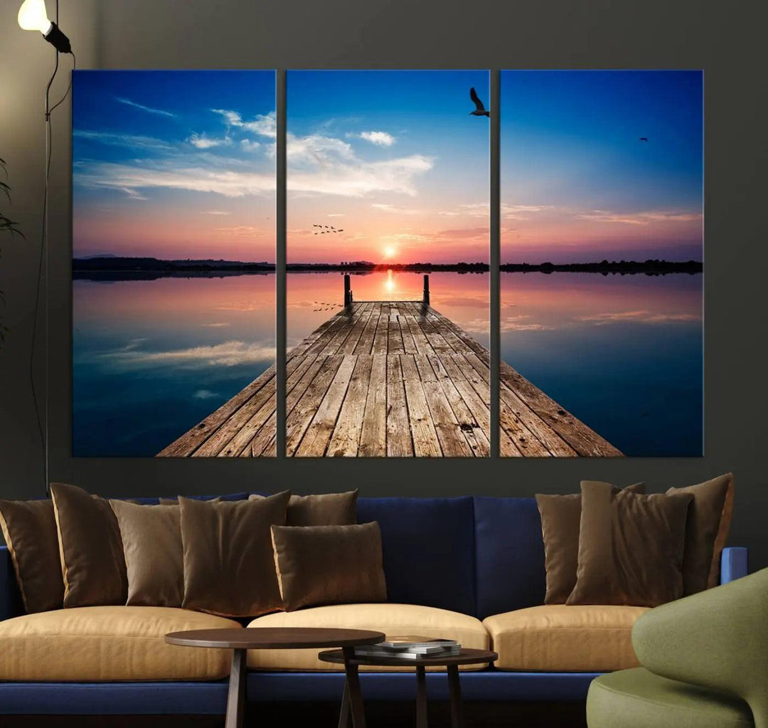 A Sea Wooden Pier Canvas Wall Art, featuring a sunset artwork print of the beach, fosters a coastal ambiance in the modern living room.