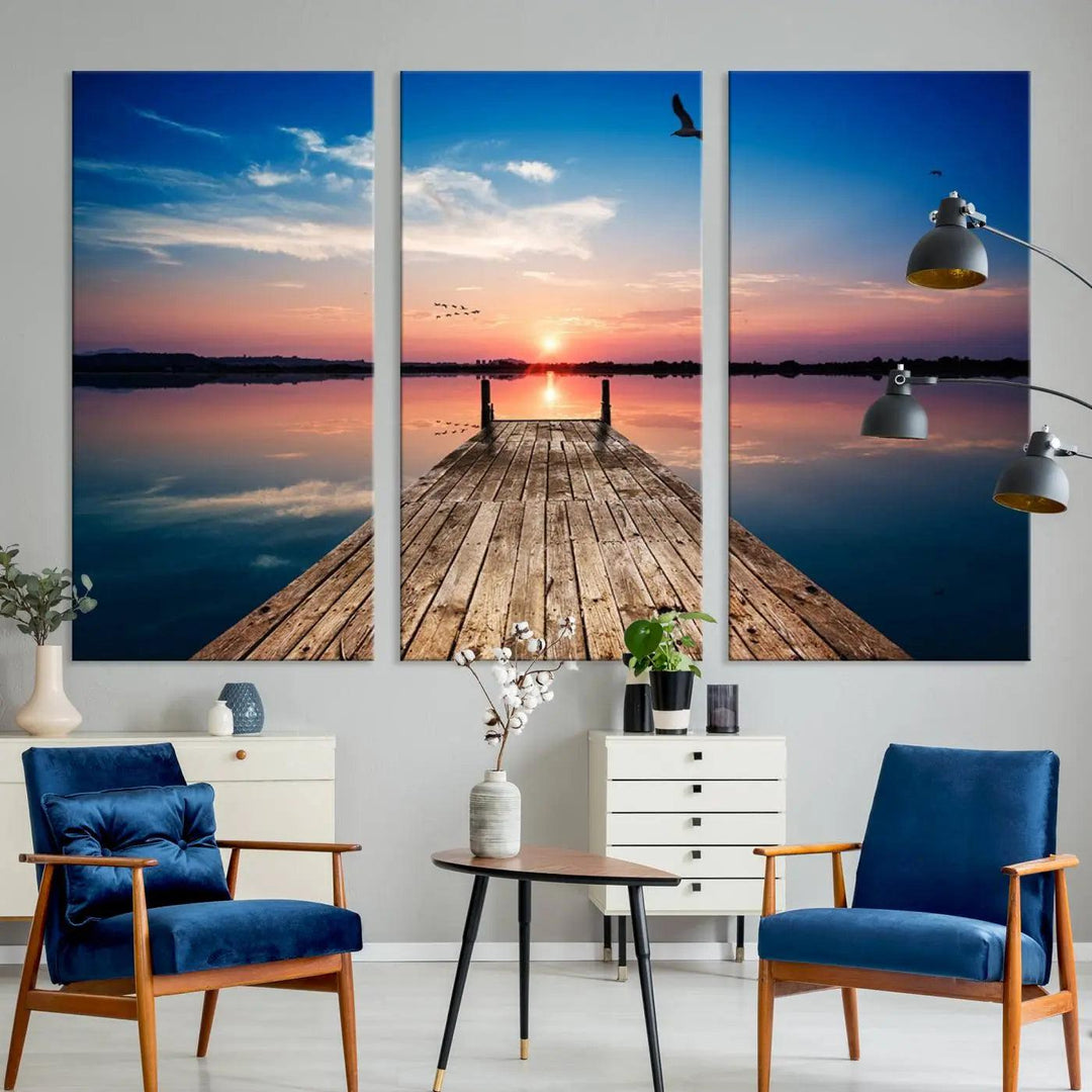 A Sea Wooden Pier Canvas Wall Art, featuring a sunset artwork print of the beach, fosters a coastal ambiance in the modern living room.