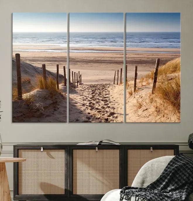 The "Serene Beach Path Canvas – Coastal Landscape Wall Art Triptych – Tranquil Ocean View for Living Room" is tastefully displayed, adding a beautiful coastal touch to the room's ambiance.