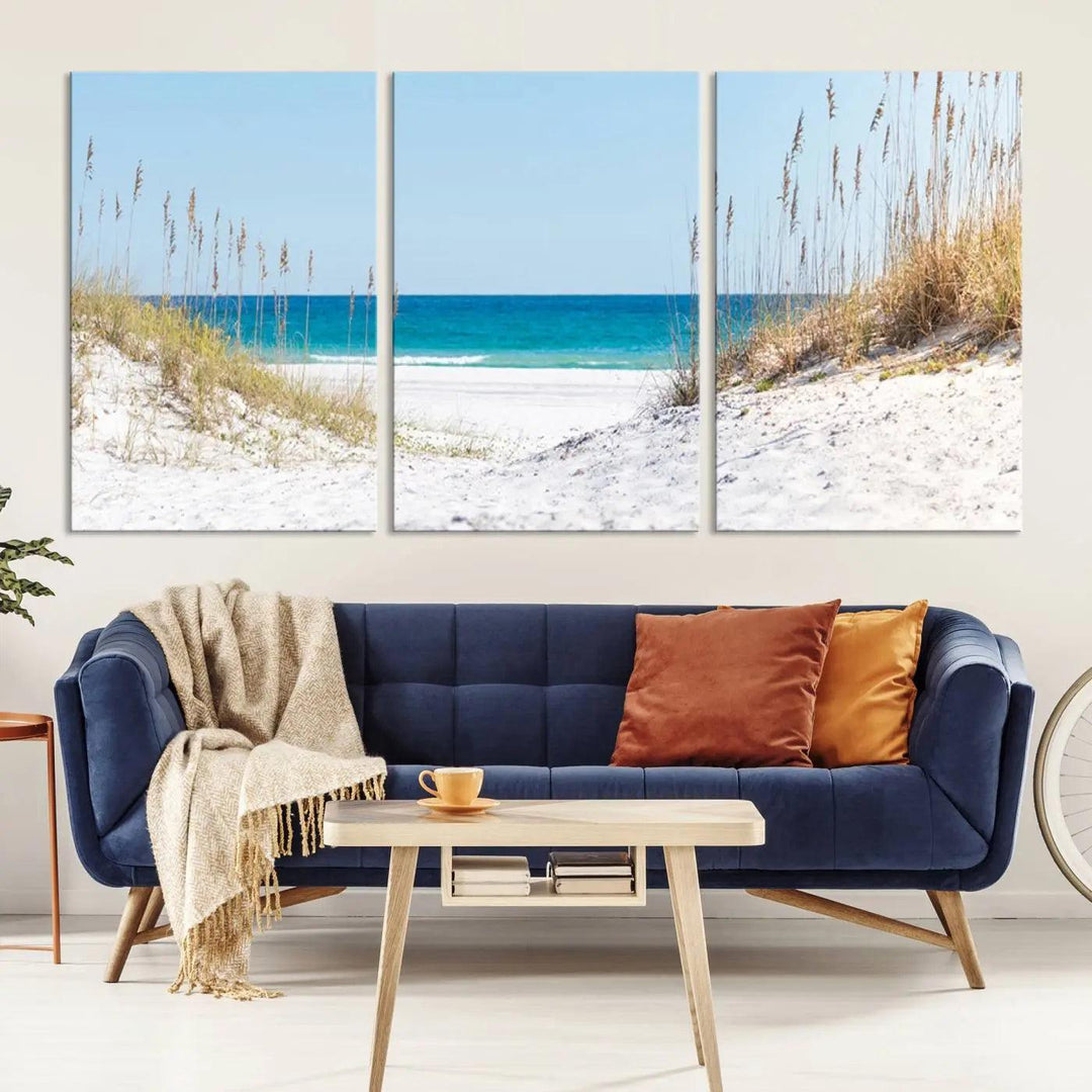 A tranquil seascape giclee print, titled "Serene Coastal Dune Path with Ocean View," features a 3-panel beach canvas wall art that captures the sandy dunes, seagrass, and ocean view to perfectly exude coastal charm.