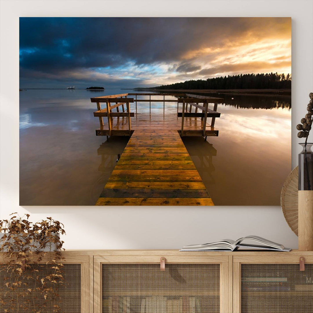 The Serene Lake Pier at Sunset canvas print depicts a wooden dock extending into a tranquil lake.