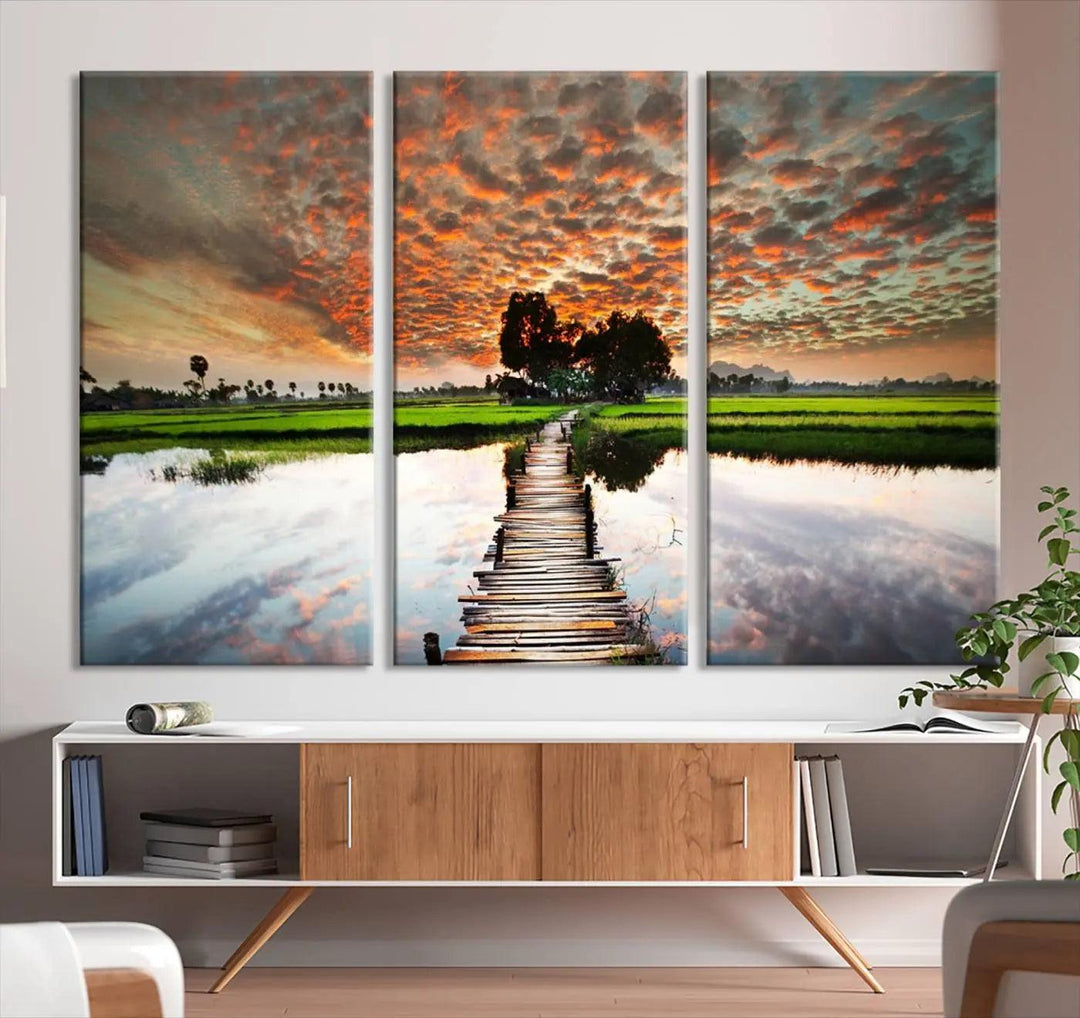 Serene sunset wooden bridge triptych canvas art. Giclee print with vibrant sunset reflections, perfect for tranquil and scenic spaces.