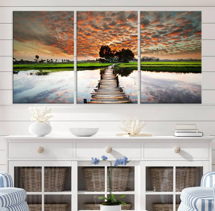 Serene sunset wooden bridge triptych canvas art. Giclee print with vibrant sunset reflections, perfect for tranquil and scenic spaces.