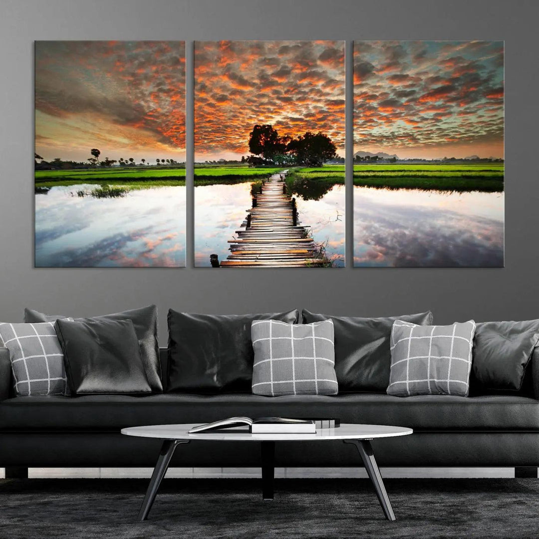 Serene sunset wooden bridge triptych canvas art. Giclee print with vibrant sunset reflections, perfect for tranquil and scenic spaces.