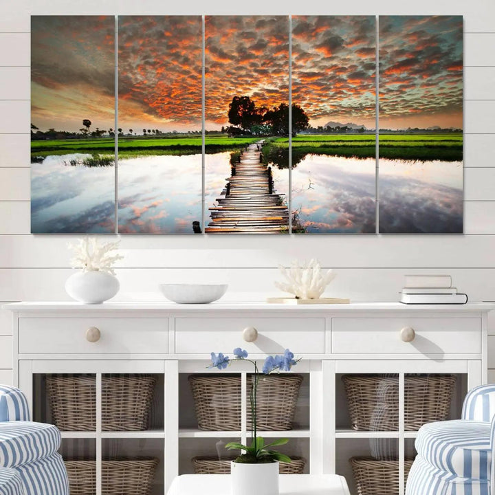 The "Serene Sunset Wooden Bridge Triptych Canvas Art" beautifully depicts a scenic landscape with reflections over water and a vibrant, cloudy sunset sky, making it an ideal choice for textured walls in tranquil spaces.