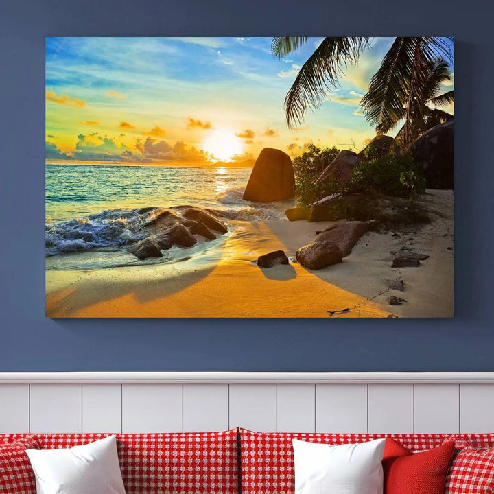 The Serene Tropical Beach Sunset Canvas Wall Art, a 3-panel giclee print, beautifully captures an ocean sunset with its depiction of palm trees and a coastal rock formation.