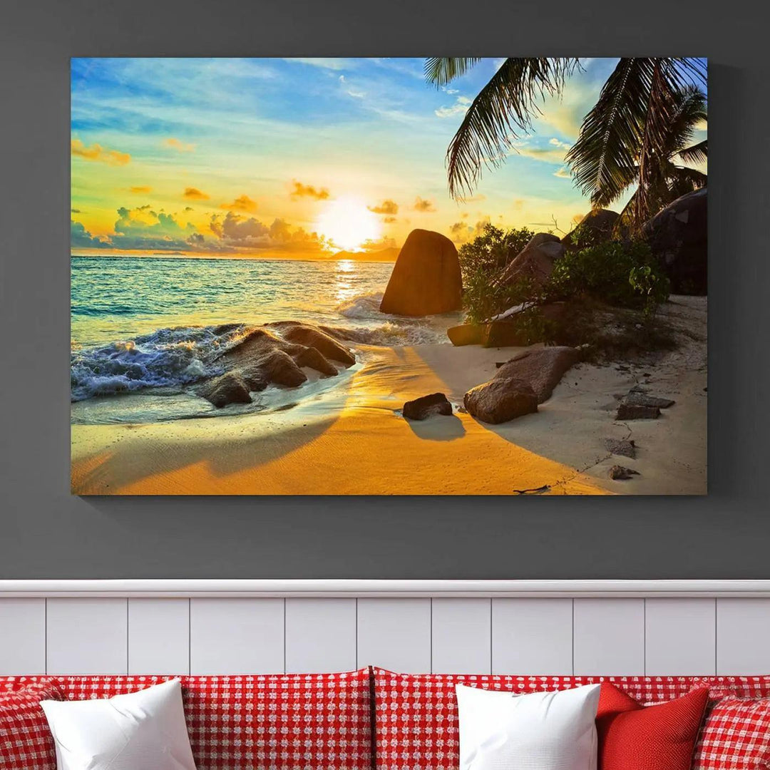 The Serene Tropical Beach Sunset Canvas Wall Art, a 3-panel giclee print, beautifully captures an ocean sunset with its depiction of palm trees and a coastal rock formation.