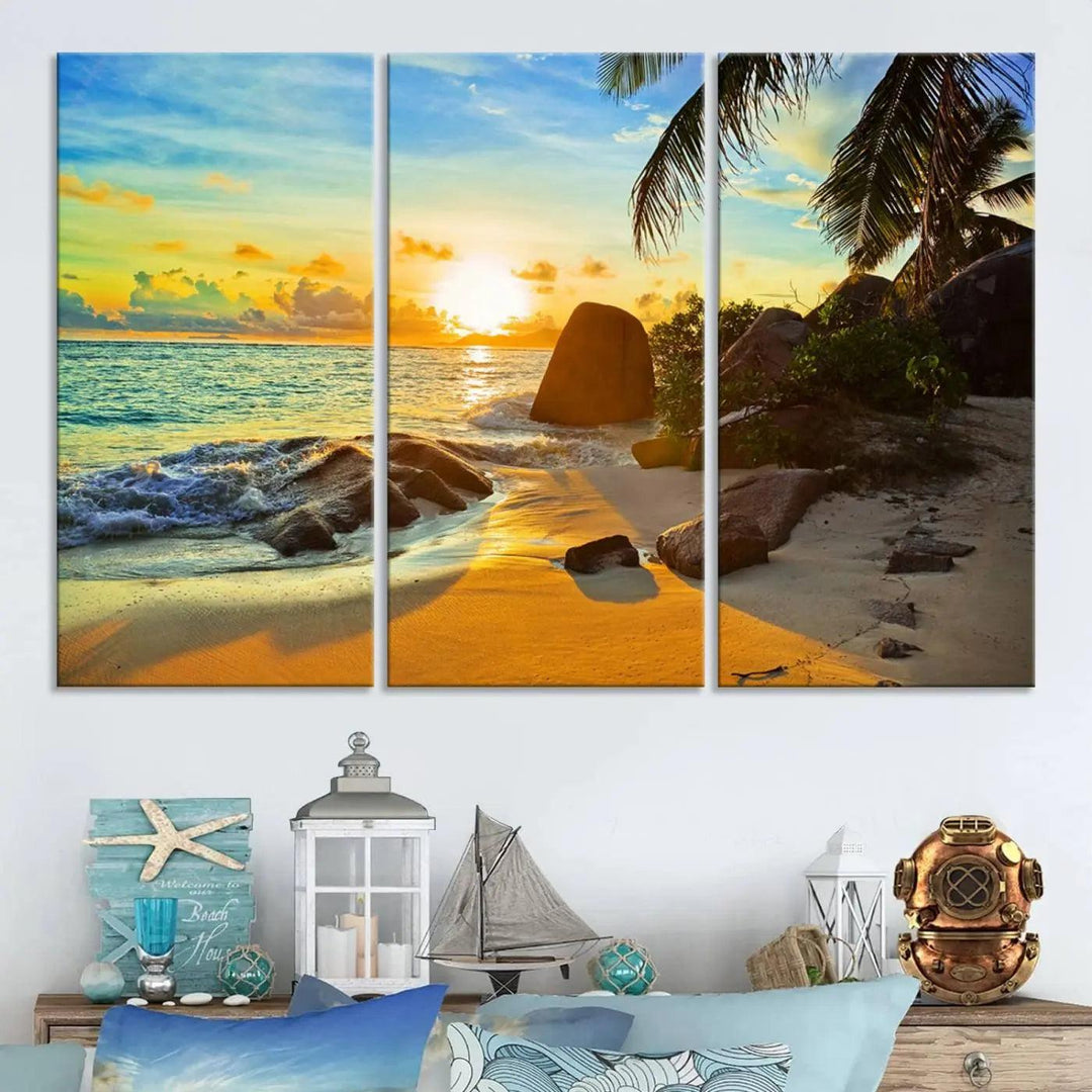 The Serene Tropical Beach Sunset Canvas Wall Art, a 3-panel giclee print, beautifully captures an ocean sunset with its depiction of palm trees and a coastal rock formation.