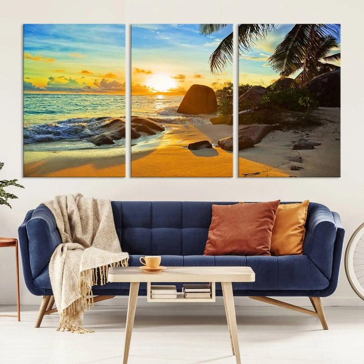 The Serene Tropical Beach Sunset Canvas Wall Art, a 3-panel giclee print, beautifully captures an ocean sunset with its depiction of palm trees and a coastal rock formation.