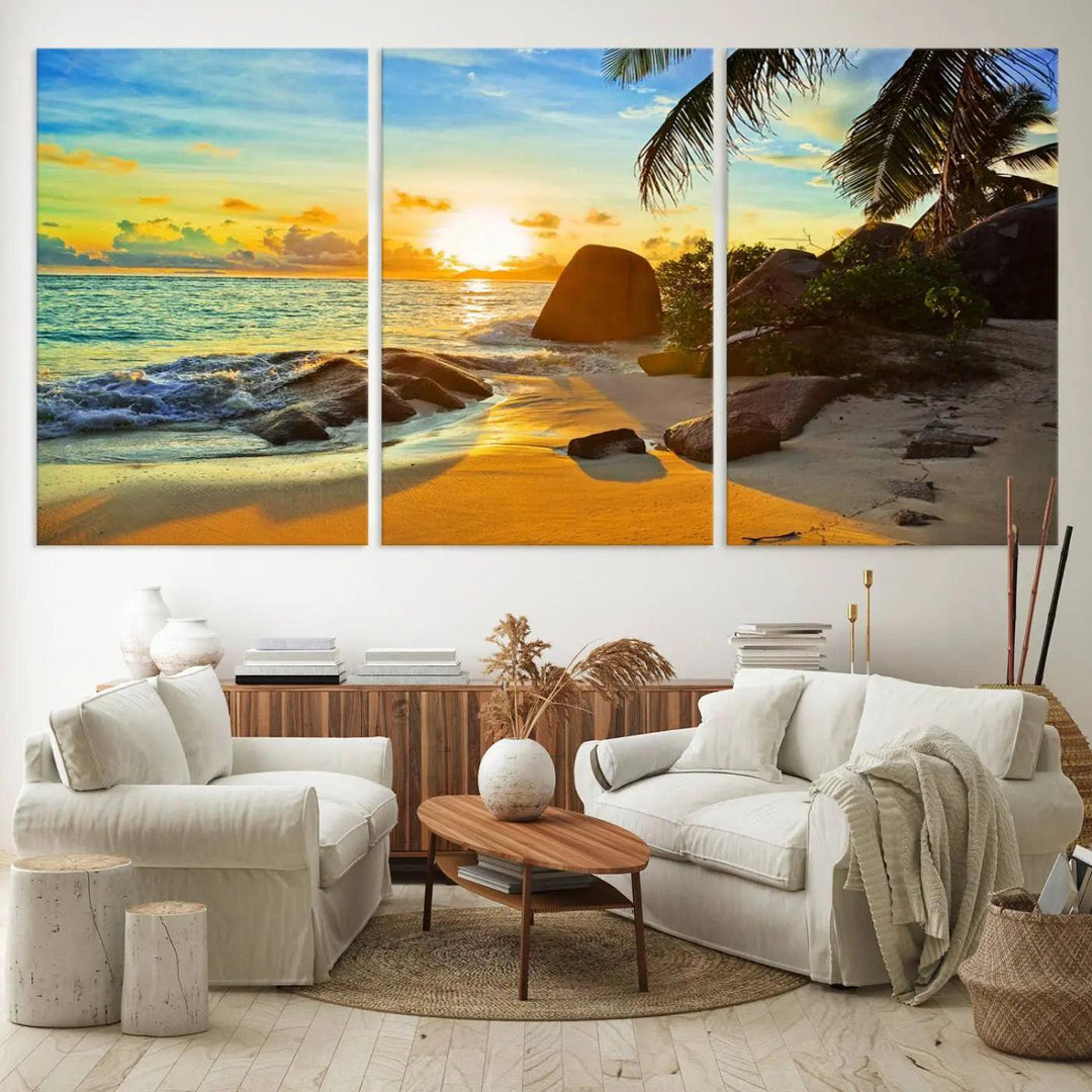 The Serene Tropical Beach Sunset Canvas Wall Art, a 3-panel giclee print, beautifully captures an ocean sunset with its depiction of palm trees and a coastal rock formation.