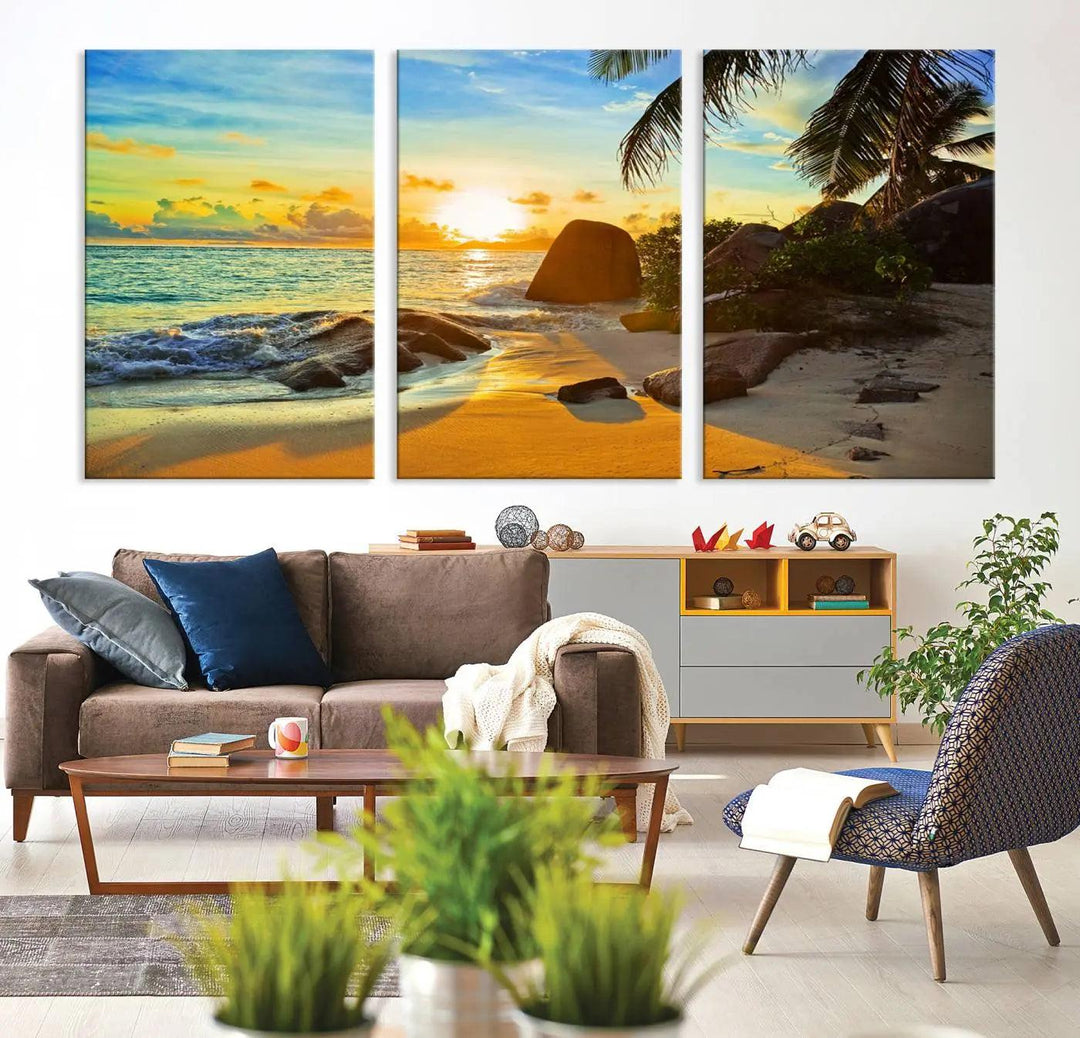 The Serene Tropical Beach Sunset Canvas Wall Art, a 3-panel giclee print, beautifully captures an ocean sunset with its depiction of palm trees and a coastal rock formation.