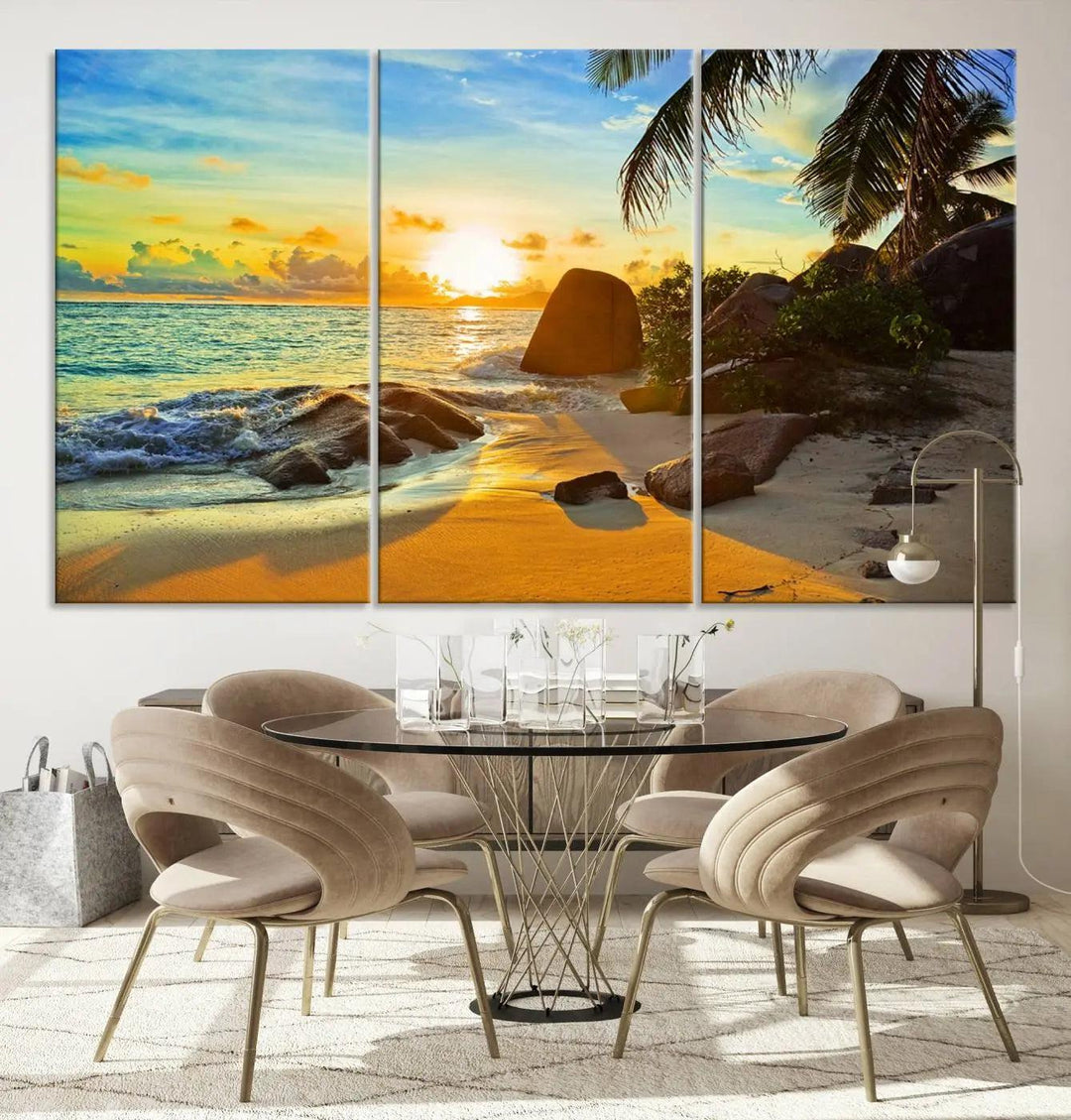 The Serene Tropical Beach Sunset Canvas Wall Art, a 3-panel giclee print, beautifully captures an ocean sunset with its depiction of palm trees and a coastal rock formation.