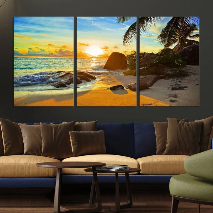 The Serene Tropical Beach Sunset Canvas Wall Art, a 3-panel giclee print, beautifully captures an ocean sunset with its depiction of palm trees and a coastal rock formation.