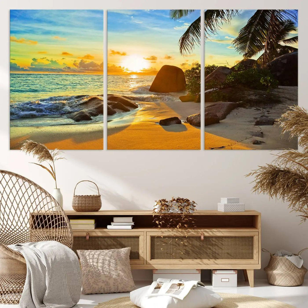 The Serene Tropical Beach Sunset Canvas Wall Art, a 3-panel giclee print, beautifully captures an ocean sunset with its depiction of palm trees and a coastal rock formation.