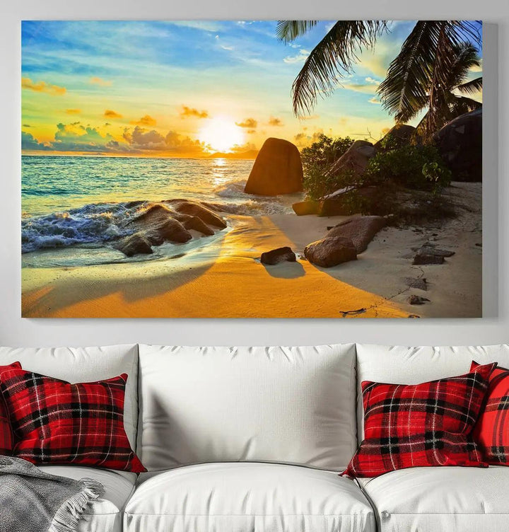 The Serene Tropical Beach Sunset Canvas Wall Art, a 3-panel giclee print, beautifully captures an ocean sunset with its depiction of palm trees and a coastal rock formation.